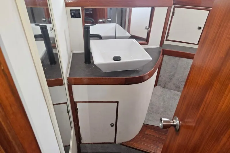 Slide: The Image of 1982 Tayana Center Cockpit Cutter Ketch bathroom with modern sink and wooden cabinetry. - 44