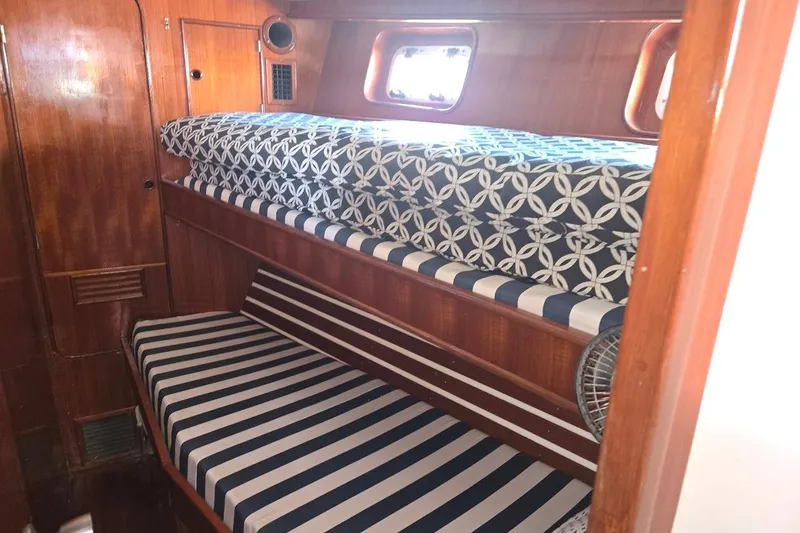 Slide: The Image of 1982 Tayana Center Cockpit Cutter Ketch cabin with striped and patterned bunk beds. - 49