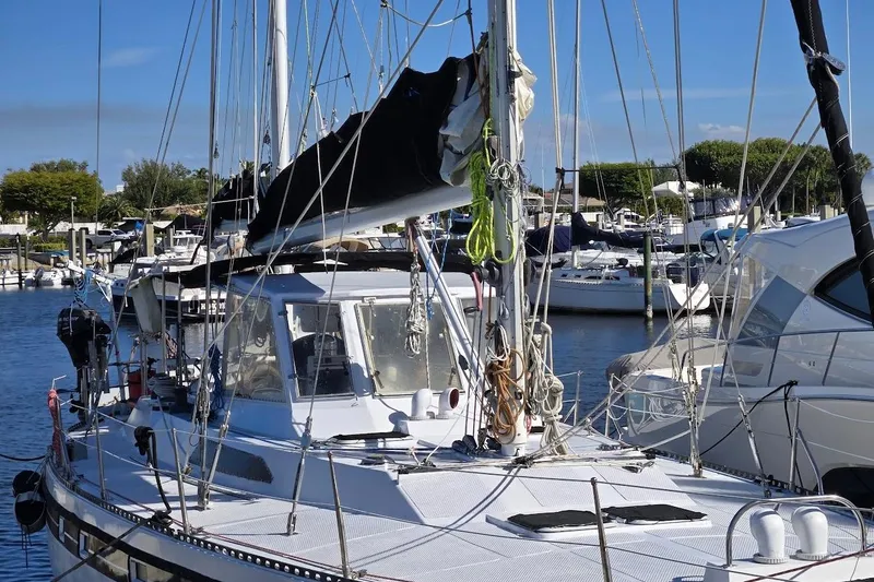 Slide: The Image of 1982 Tayana Center Cockpit Cutter Ketch docked in a marina, surrounded by other boats. - 52
