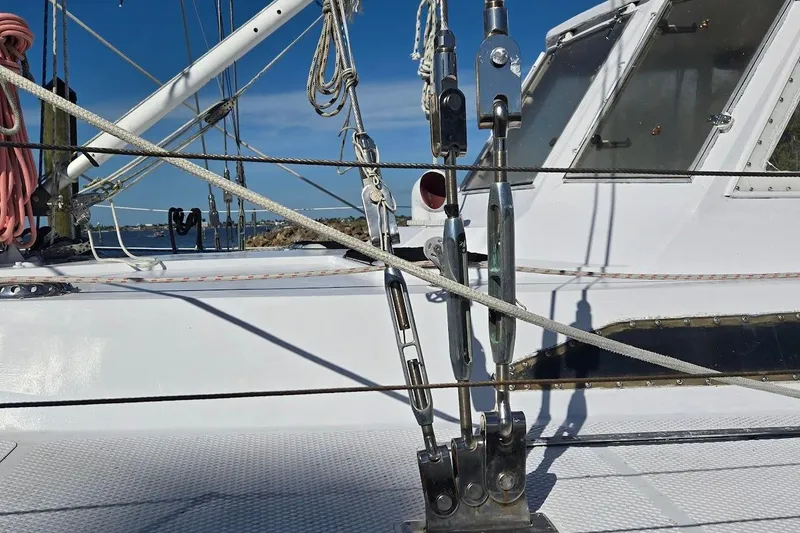 Slide: The Image of 1982 Tayana Center Cockpit Cutter Ketch deck with rigging and ropes under clear blue sky. - 59