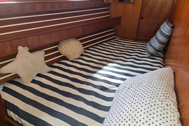 Slide: The Image of Cozy cabin interior of 1982 Tayana Center Cockpit Cutter Ketch with striped bedding and nautical decor. - 6
