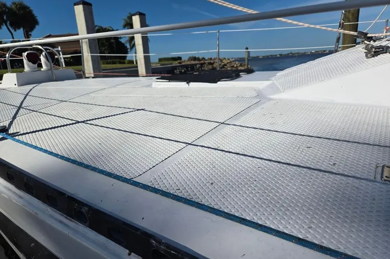 Slide: The Image of 1982 Tayana Center Cockpit Cutter Ketch deck with textured surface, docked by the water. - 65