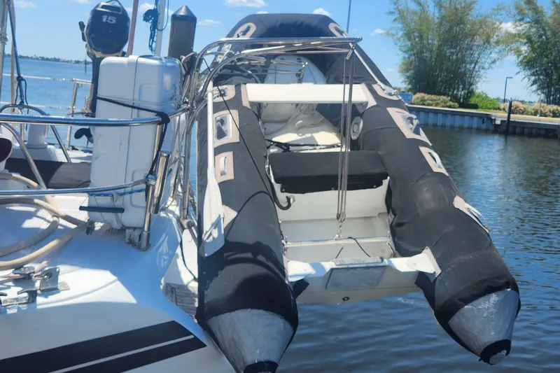 Slide: The Image of 1982 Tayana Center Cockpit Cutter Ketch with inflatable dinghy on deck, docked by the water. - 67