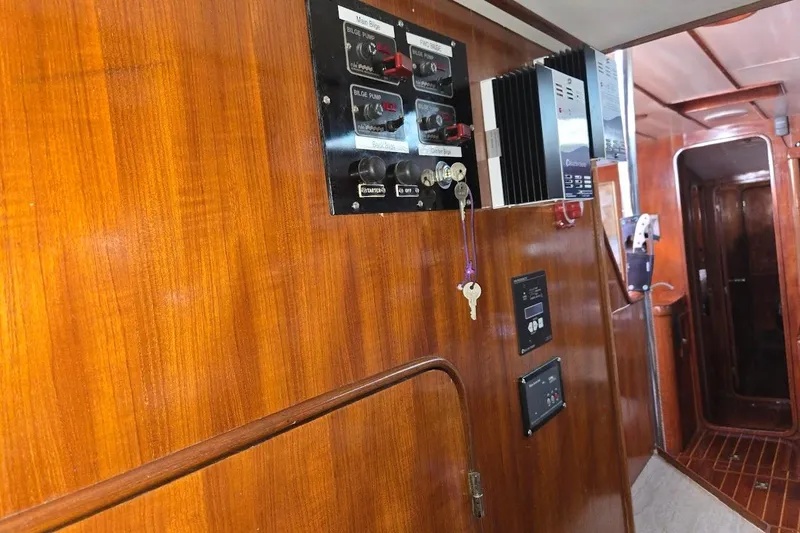 Slide: The Image of 1982 Tayana Center Cockpit Cutter Ketch interior with wooden paneling and control panels. - 69