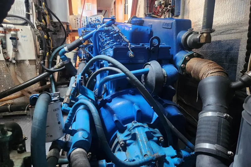 Slide: The Image of Engine room of 1982 Tayana Center Cockpit Cutter Ketch with blue machinery and hoses. - 73