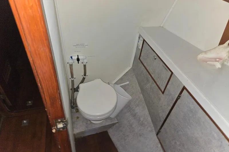 Slide: The Image of 1982 Tayana Center Cockpit Cutter Ketch bathroom with toilet and storage cabinets. - 9