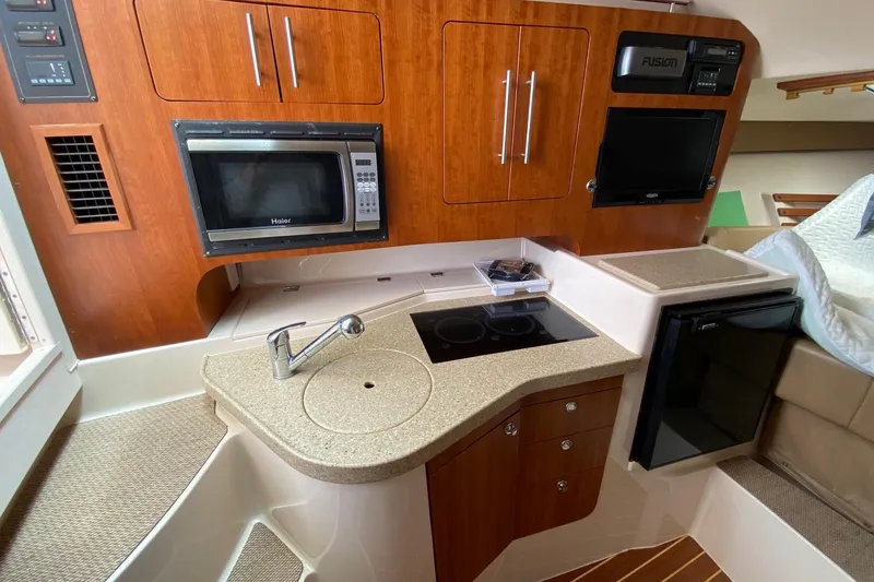 Slide: The Image of 2013 Grady-White Express 330 boat interior with kitchenette, microwave, and compact fridge. - 12