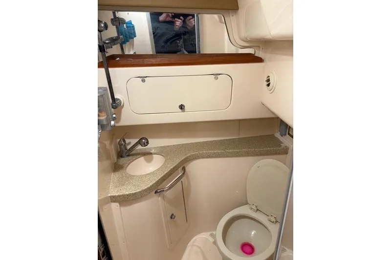 Slide: The Image of 2013 Grady-White Express 330 boat bathroom with sink, toilet, and storage cabinet. - 14