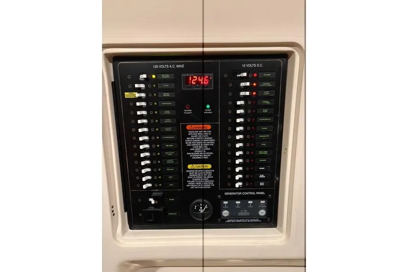 Slide: The Image of Electrical control panel of 2013 Grady-White Express 330 boat, showing voltage and switches. - 16