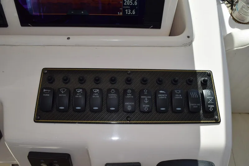 Slide: The Image of Control panel of a 2013 Grady-White Express 330 boat with labeled switches. - 23