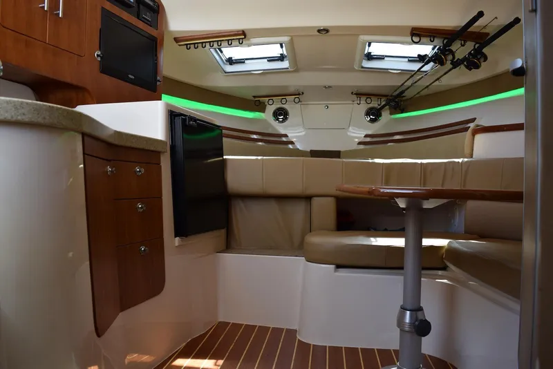 Slide: The Image of Interior of 2013 Grady-White Express 330 boat with seating, table, and fishing rods. - 25