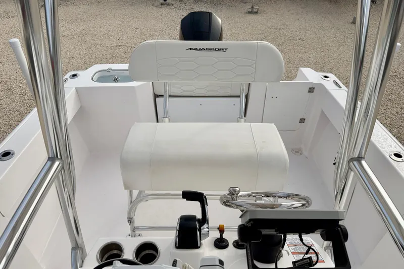 Slide: The Image of 2023 Aquasport 220 CC boat interior with steering wheel and seating. - 15