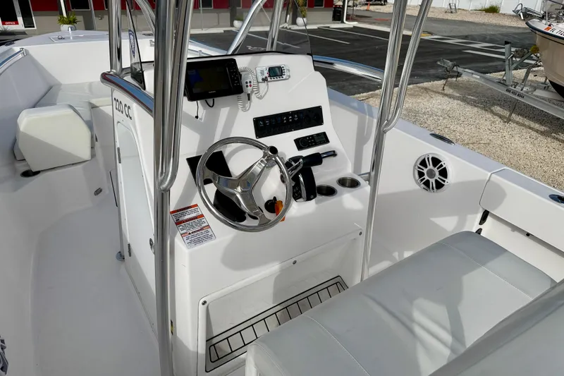 Slide: The Image of 2023 Aquasport 220 CC boat interior with steering console and seating. - 19