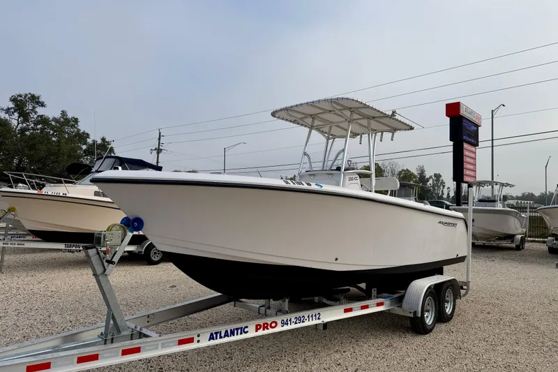 Slide: The Image of 2023 Aquasport 220 CC boat on trailer at dealership, ready for sale. - 2