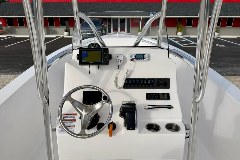 Slide: The Image of 2023 Aquasport 220 CC boat console with steering wheel, navigation, and control panel. - 20