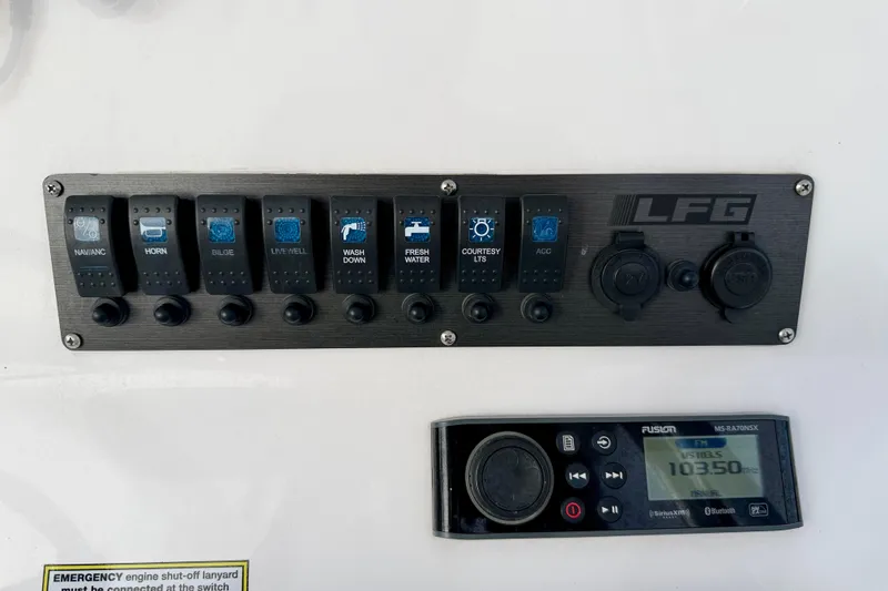 Slide: The Image of Control panel of 2023 Aquasport 220 CC boat with switches and radio display. - 24
