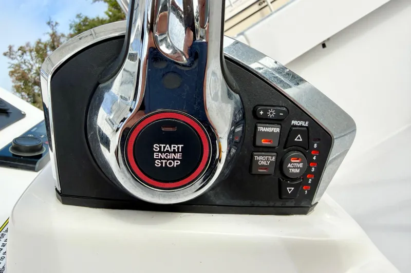 Slide: The Image of 2023 Aquasport 220 CC engine control panel with start-stop button and trim settings. - 26