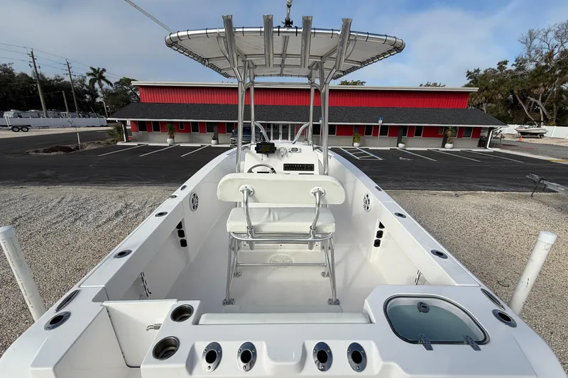 Slide: The Image of 2023 Aquasport 220 CC boat with T-top and seating, parked in a lot. - 27