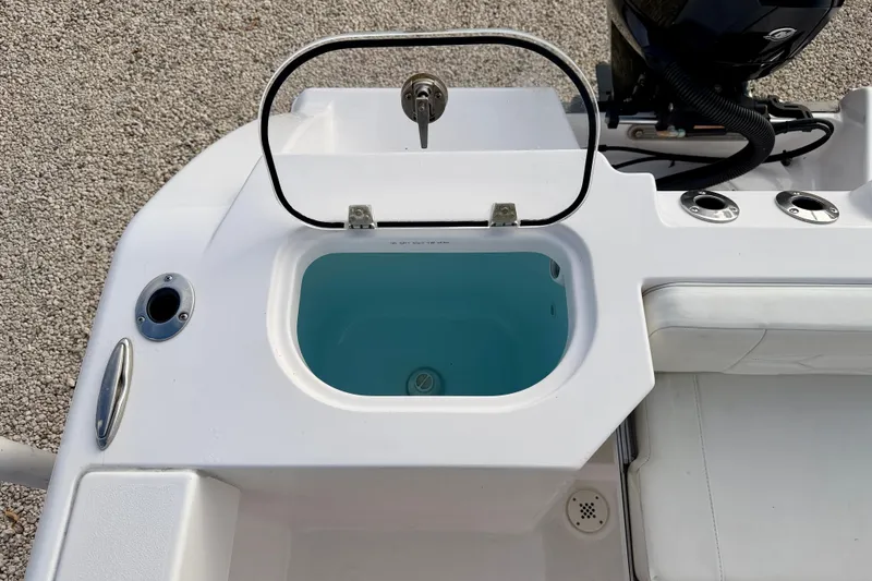 Slide: The Image of 2023 Aquasport 220 CC boat livewell with open lid, showcasing interior features. - 30