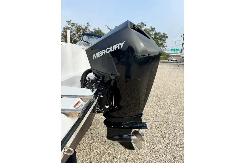 Slide: The Image of 2023 Aquasport 220 CC with Mercury outboard motor, parked on gravel. - 31
