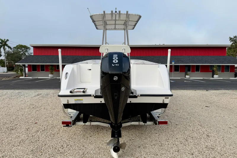 Slide: The Image of 2023 Aquasport 220 CC boat with powerful V6 engine, parked on gravel. - 6