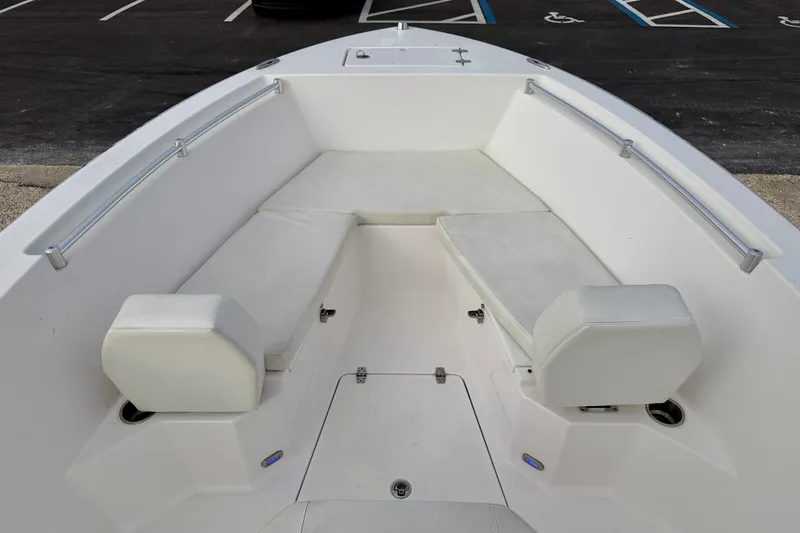 Slide: The Image of 2023 Aquasport 220 CC boat interior with white cushioned seating and stainless steel rails. - 9