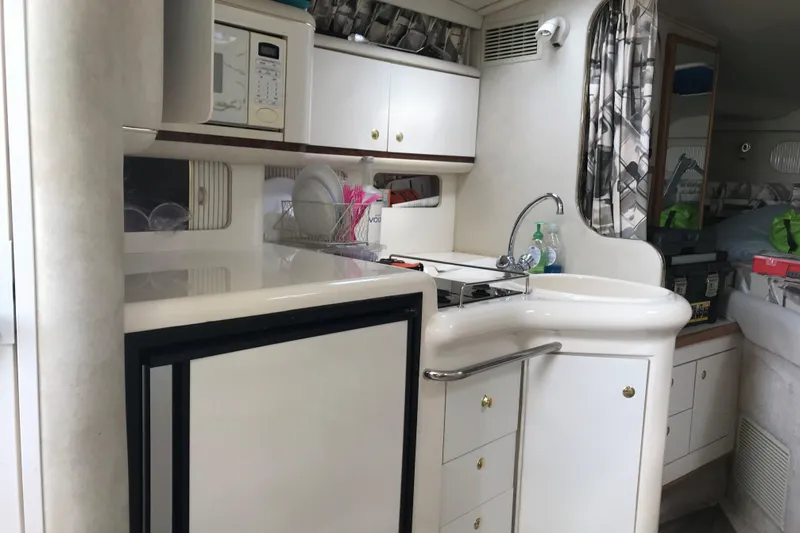 Slide: The Image of 1997 Sea Ray Sundancer 330 interior kitchen with sink, microwave, and storage cabinets. - 12
