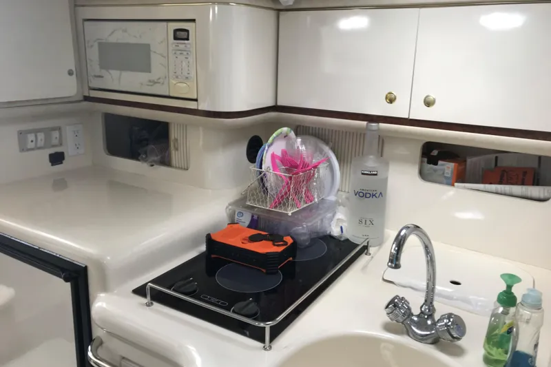 Slide: The Image of 1997 Sea Ray Sundancer 330 kitchen with microwave, stove, and sink. - 13
