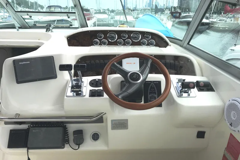 Slide: The Image of 1997 Sea Ray Sundancer 330 helm with steering wheel, controls, and navigation equipment. - 2