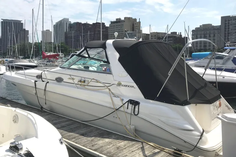 Slide: The Image of 1997 Sea Ray Sundancer 330 docked at marina with city skyline backdrop. - 3