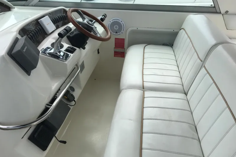 Slide: The Image of Interior of 1997 Sea Ray Sundancer 330 boat with white seating and steering wheel. - 6