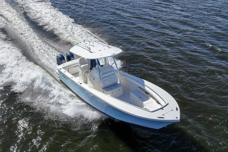 Slide: The Image of 2014 Regulator 25 boat cruising on open water, creating waves and splashes. - 1