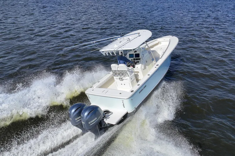 Slide: The Image of 2014 Regulator 25 boat cruising on a scenic waterway with palm trees and blue sky. - 10