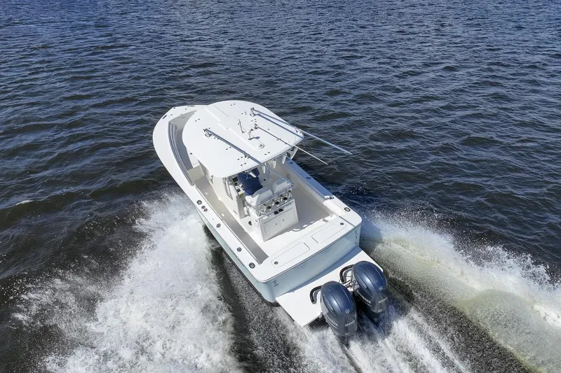 Slide: The Image of 2014 Regulator 25 boat cruising on a scenic waterway near luxury homes. - 11