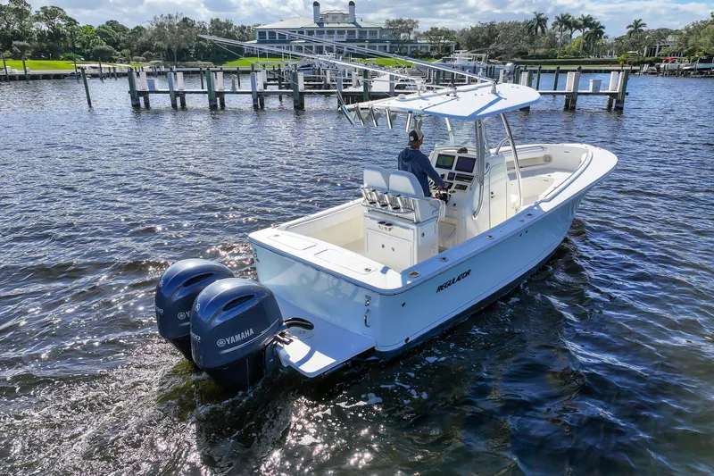 Slide: The Image of 2014 Regulator 25 boat with dual Yamaha engines cruising on a sunny day. - 16