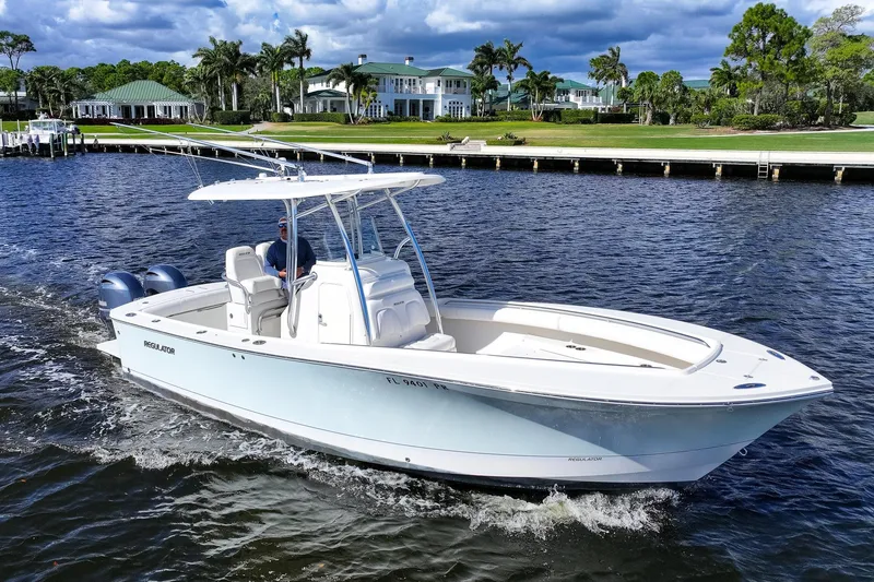 Slide: The Image of 2014 Regulator 25 boat cruising on open water, creating a wake. - 2