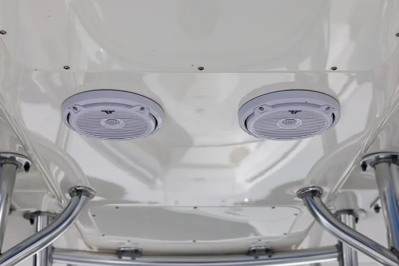 Slide: The Image of 2014 Regulator 25 boat with white cushioned seating and storage compartments. - 20