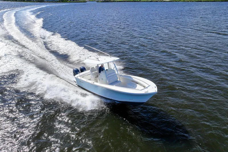 Slide: The Image of 2014 Regulator 25 boat cruising on open water, creating a wake. - 3