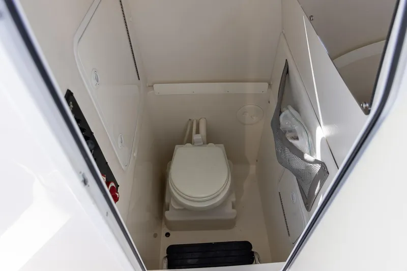 Slide: The Image of 2014 Regulator 25 boat interior with compact marine toilet and storage. - 33