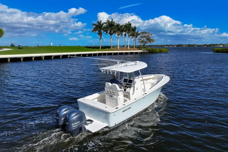 Slide: The Image of 2014 Regulator 25 boat cruising on water with twin Yamaha engines. - 6