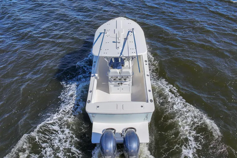 Slide: The Image of 2014 Regulator 25 boat cruising on a scenic waterway with palm trees and blue sky. - 8