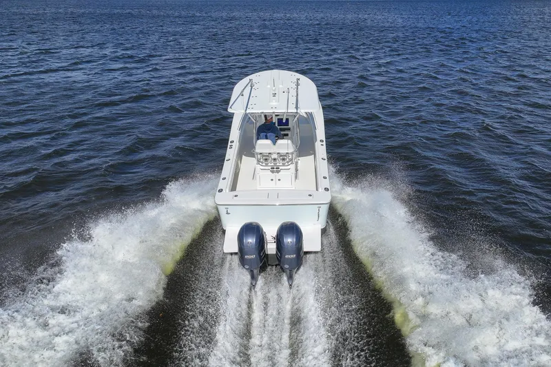Slide: The Image of 2014 Regulator 25 boat cruising on a scenic waterway with palm trees and blue sky. - 9