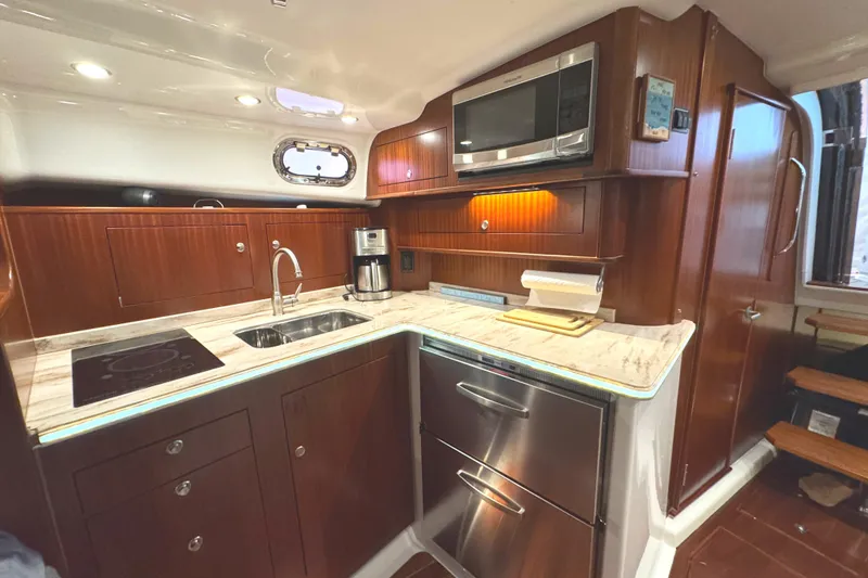 Slide: The Image of Luxurious 2019 Pursuit OS 385 Offshore yacht kitchen with modern appliances and wood cabinetry. - 12
