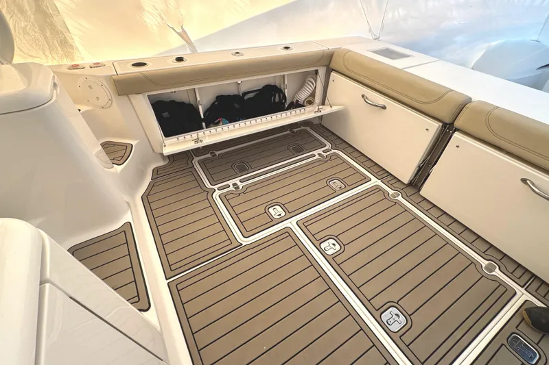 Slide: The Image of 2019 Pursuit OS 385 Offshore boat interior with storage compartments and teak-style flooring. - 18