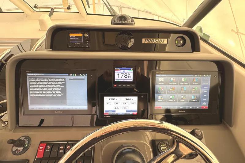 Slide: The Image of 2019 Pursuit OS 385 Offshore helm with advanced Garmin navigation displays and controls. - 2