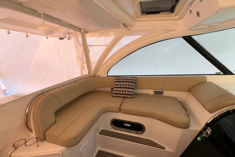 Slide: The Image of 2019 Pursuit OS 385 Offshore interior with beige seating and patterned cushion. - 26