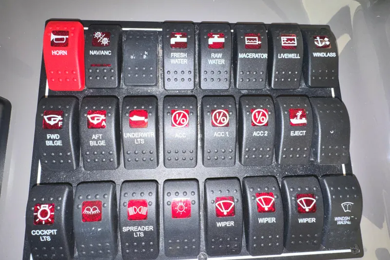 Slide: The Image of Control panel of a 2019 Pursuit OS 385 Offshore boat with labeled switches. - 27