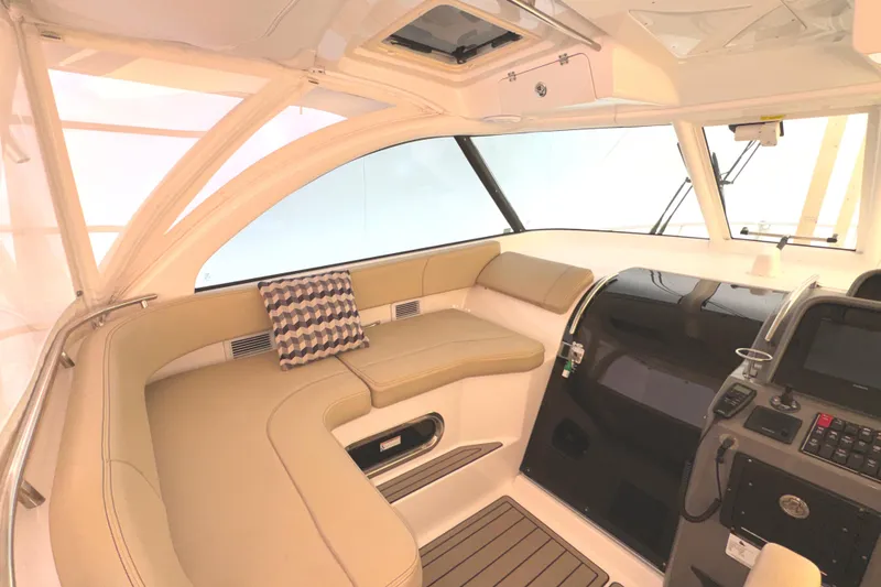 Slide: The Image of 2019 Pursuit OS 385 Offshore interior with beige seating and modern helm controls. - 29