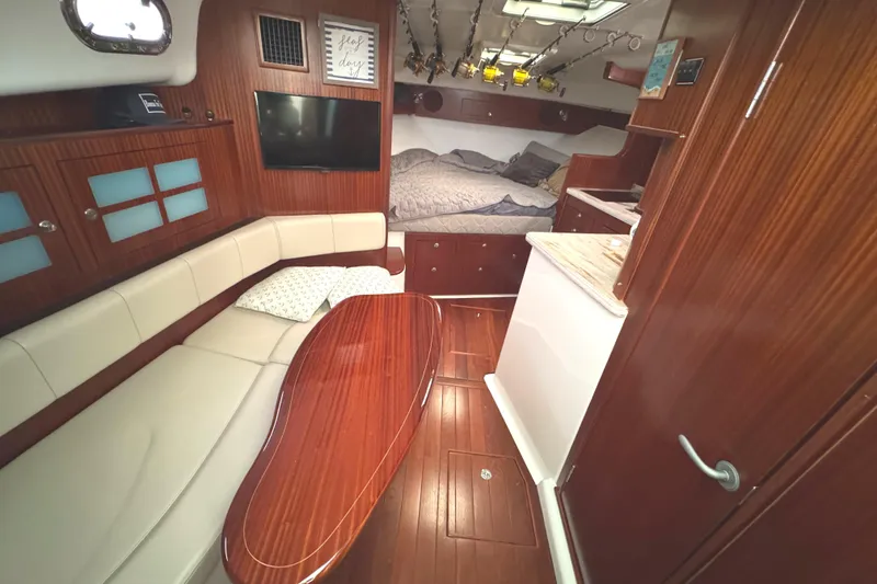 Slide: The Image of Luxurious 2019 Pursuit OS 385 Offshore cabin interior with wood finishes and cozy seating. - 4
