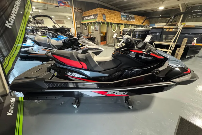 Slide: The Image of 2026 Kawasaki ULTRA 160LX-S jet ski in showroom, black and red design. - 6
